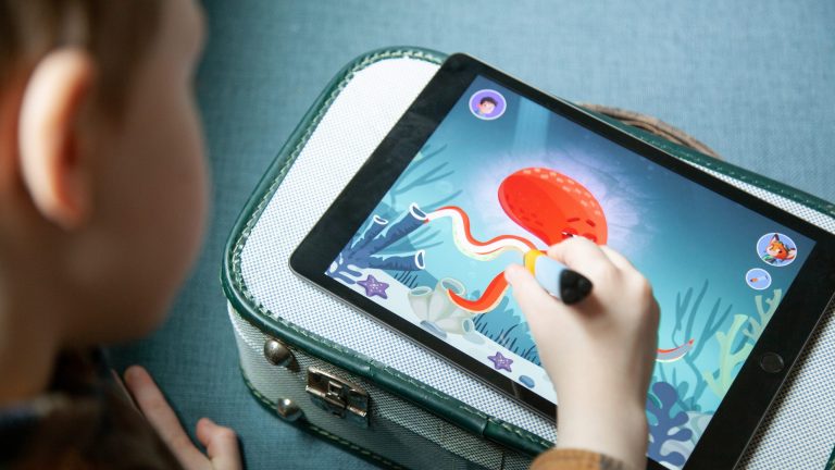 Ein Kind spielt mit einem digitalen Stift auf einem Tablet, auf dem die Edurino-App läuft.