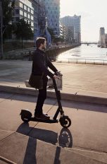 Eine Person fährt mit einem E-Scooter durch die Hamburger Hafen City.