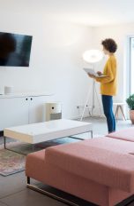Eine Person steht mit einem Laptop vor einem Fernseher.