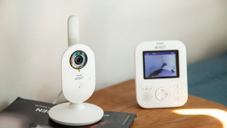 Philips Avent Video-Babyphone Das Babyphon Avent SCD 833/26 von Philips steht auf einer Sofalehne. Auf dem Display ist der Blick in ein Kinderzimmer zu erkennen.