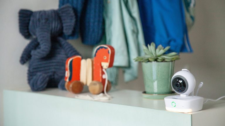 Reer Video-Babyphone IP BabyCam Smart Die IP Babycam Move von Reer steht auf einer Anrichte. Daneben stehen unter anderem ein Holzpferd und ein Stoffelefant.