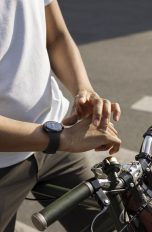 Eine Person sitzt auf einem Fahrrad und trägt eine Google Pixel Watch am rechten Handgelenk.