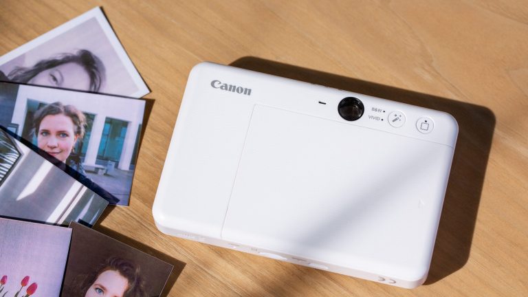 Canon Zoemini 2 Detailansicht der Rückseite einer Canon Zoemini S2. Daneben liegen einige fertige Fotos.