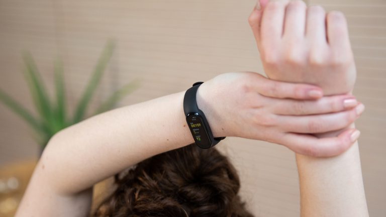Xiaomi Mi Smart Band 6 Eine Person trägt ein Xiaomi Mi Smart Band 6 bei einer Yoga-Sitzung.
