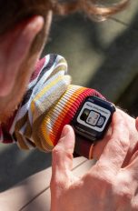 Eine Person blickt auf die Apple Watch, die sie am linken Arm trägt und stellt sie ein.