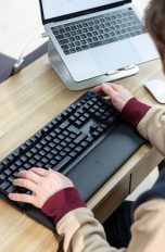 Eine Person sitzt an einem Schreibtisch vor einer Razer Huntsman V2.