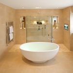 Ein Badezimmer mit freistehender Badewanne und einem Fernseher in der Wand.