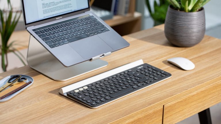 Logitech K780 Eine Logitech K780 liegt vor einem MacBook Pro. Neben der Tastatur liegt eine Apple Magic Mouse.