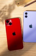 Auf einem Tisch liegen mit der Rückseite nach oben iPhone 13, iPhone 12 und iPhone SE.