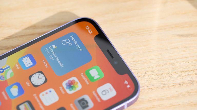 iPhone 12 Das iPhone 12 liegt auf einem Tisch.