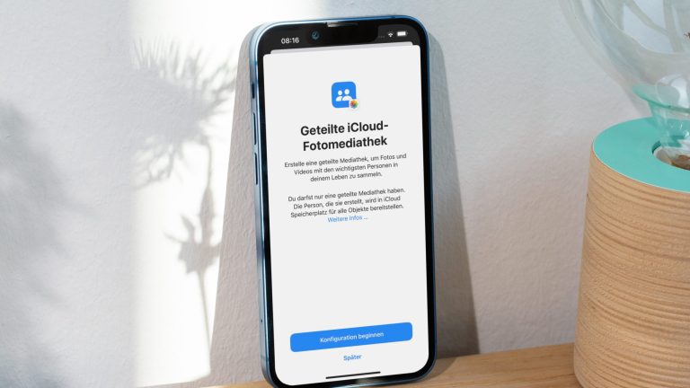 iOS 16 Public Beta Ein iPhone 13 Pro Max lehnt an einer Wand. Auf dem Bildschirm ist der Einrichtungsprozess für die neue geteilte iCloud-Fotomediathek zu sehen.