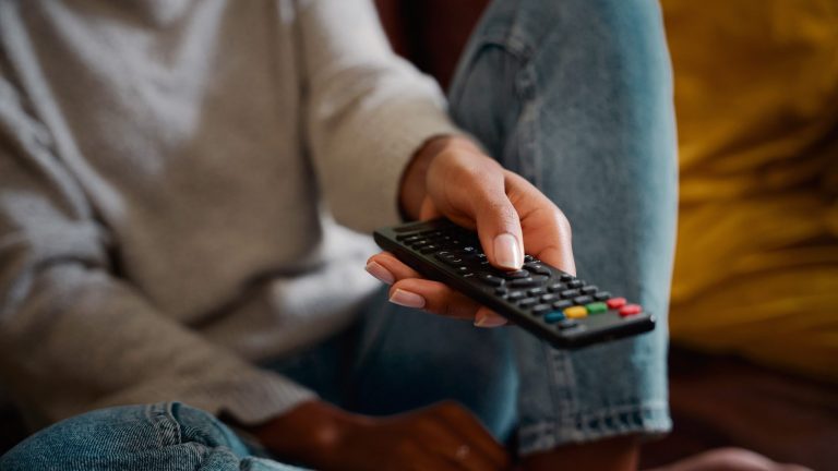 Fernseher USB Recording Eine Person hält eine Fernbedienung in der Hand.