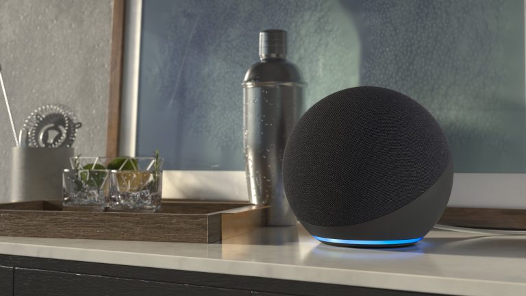Alexa Sprachassistenz Ein Echo Dot steht auf einem Sideboard neben einigen Gläsern und einem Cocktailshaker.
