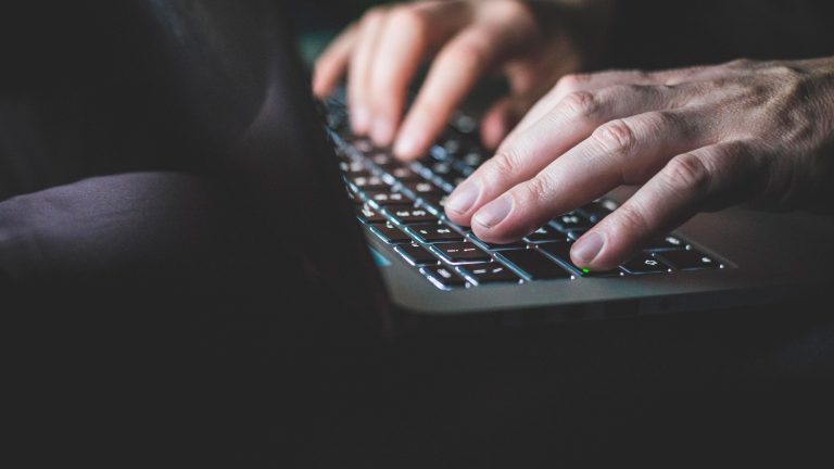 Apple Passkey Nahaufnahme von zwei Händen, die gerade auf einer Tastatur tippen.