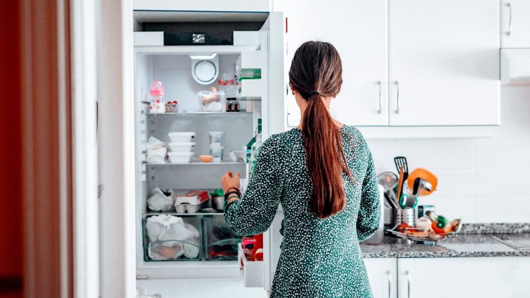 Einbaukühlschrank ausbauen Eine Person öffnet einen Einbaukühlschrank. Darin sind einige Lebensmittel zu sehen.