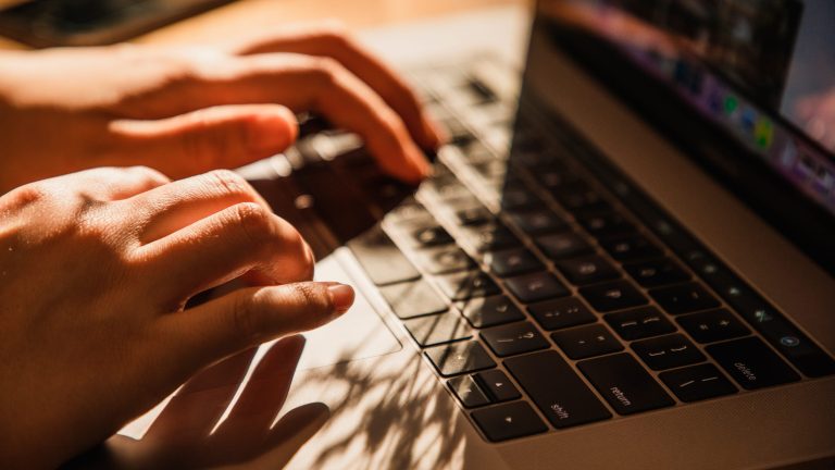Passwörter verwalten Zwei Hände tippen auf einem Laptop.
