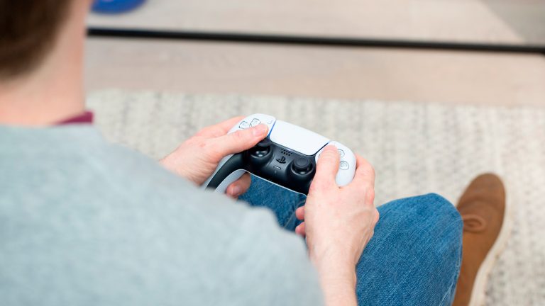 Eine Person hält den DualSense Controller der PlayStation 5 in den Händen. Eine Person hält den DualSense Controller der PlayStation 5 in den Händen.