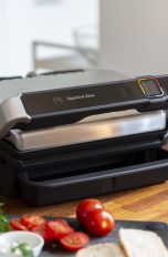 Ein Tefal Optigrill Elite steht auf einem Tisch neben diversen Zutaten.