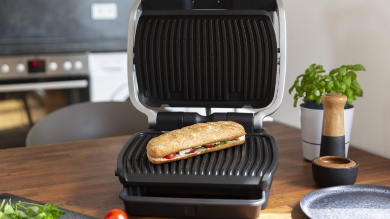 Tefal Optigrill Elite In einem aufgeklappten Optigrill liegt ein Sandwich.