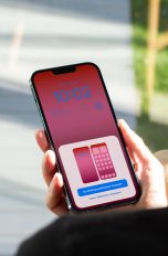Eine Person hält ein iPhone in der Hand, auf dem gerade die Einstellungsoptionen des Sperrbildschirms zu sehen sind.