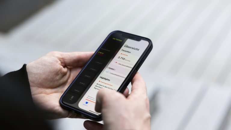 iPhone Gesten Eine Person hält ein iPhone 12 in den Händen. Darauf ist die Health-App zu sehen, die gerade nach rechts geschoben wird.