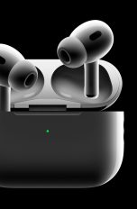 Die neuen AirPods Pro präsentieren sich hier vor einem schwarzen Hintergrund. Der rechte Kopfhörer steckt im Ladecase, während der linke etwas darüber schwebt.