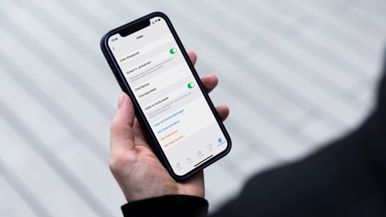 WhatsApp Smartphone Wechsel Eine Person hält ein iPhone in der Hand. Darauf sind die Einstellungen von WhatsApp zu sehen.