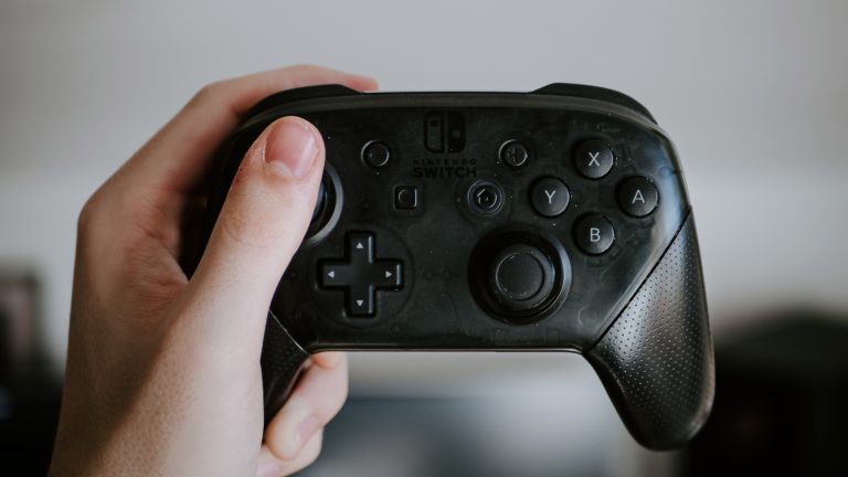 Eine Person hält einen Pro Controller für die Nintendo Switch in der Hand.