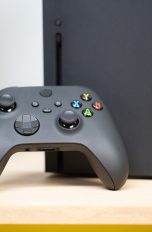 Ein Xbox Wireless Controller ist an eine Xbox Series X gelehnt.