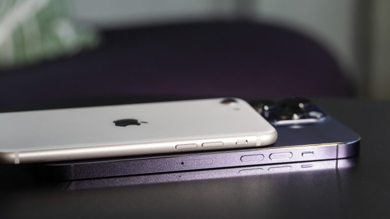 Ein iPhone SE liegt auf einem iPhone 14 Pro Max, um die Unterschiede beim Design zu verdeutlichen. iPhone 14 Pro Max vs. iPhone SE
