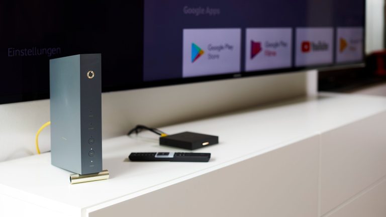 Eine Vodafone Station steht vor einem Fernseher, an den eine Streaming-Box angeschlossen ist.