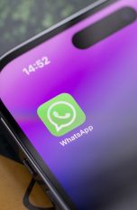 Nahaufnahme eines iPhone 14 Pro, auf dessen Display die WhatsApp-App zu sehen ist.