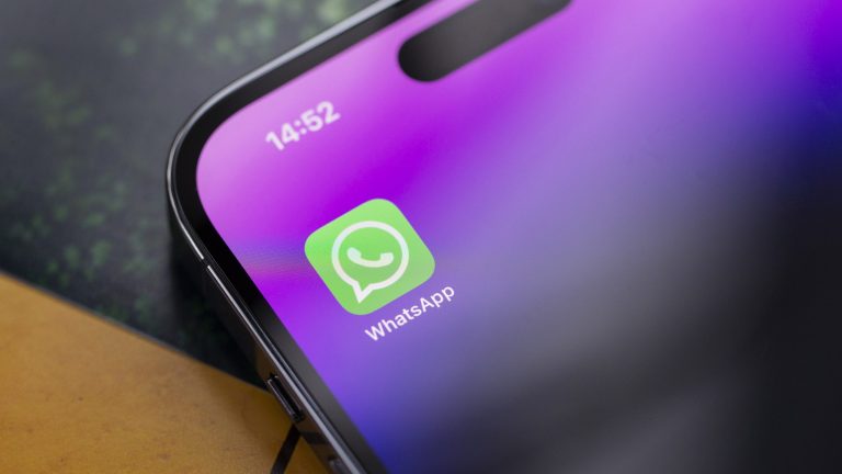 Nahaufnahme eines iPhone 14 Pro, auf dessen Display die WhatsApp-App zu sehen ist.