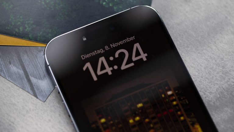 Nahaufnahme eines iPhone 14 Pro Max, auf dessen Bildschirm ein Albumcover zu sehen ist. iPhone 14 Pro Max Always On Display