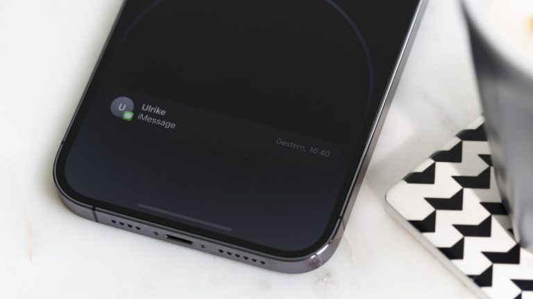 Nahaufnahme eines iPhone 14 Pro Max, an dessen unterem Bildschirmrand eine Mitteilung zu einer eingegangenen iMessage zu erkennen ist. iPhone 14 Pro Max Always On Display