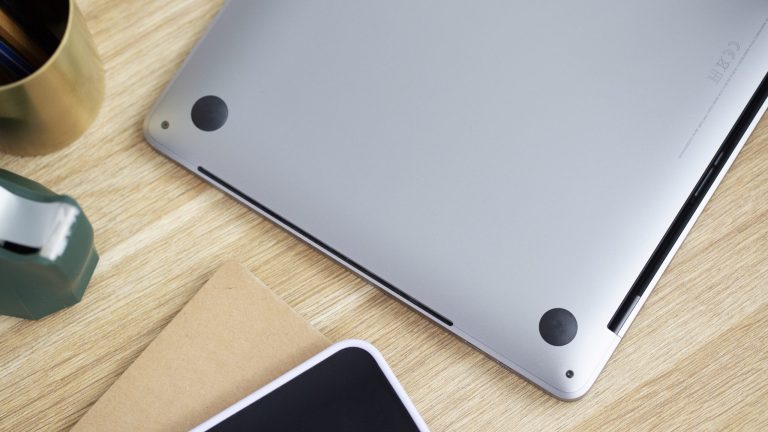 Ein umgedrehtes MacBook liegt auf einem Tisch. Zu sehen sind die schmalen Lüftungsschlitze.