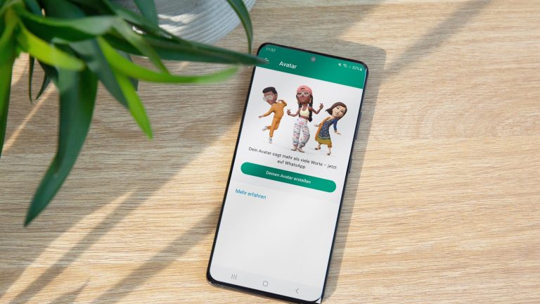 Ein Smartphone, auf dem WhatsApp geöffnet ist, liegt auf einem Holztisch.
