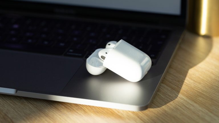 AirPods liegen in ihrem Case auf einem MacBook Pro. AirPods liegen in ihrem Case auf einem MacBook Pro.