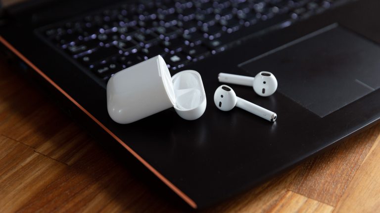 Nahaufnahme von AirPods mit Case, die auf einem Windows-Laptop liegen. Nahaufnahme von AirPods mit Case, die auf einem Windows-Laptop liegen.