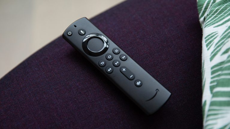 Eine Fernbedienung für einen Fire TV Stick liegt auf einem Sessel.