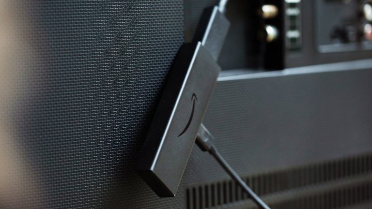 Ein Fire TV Stick ist hinten an einen Fernseher angeschlossen.