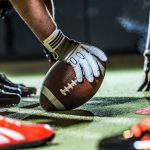 Nahaufnahme eines Footballs an der Line of Scrimmage.
