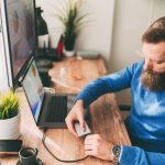 Eine Person steckt eine externe Festplatte an einen Laptop an.