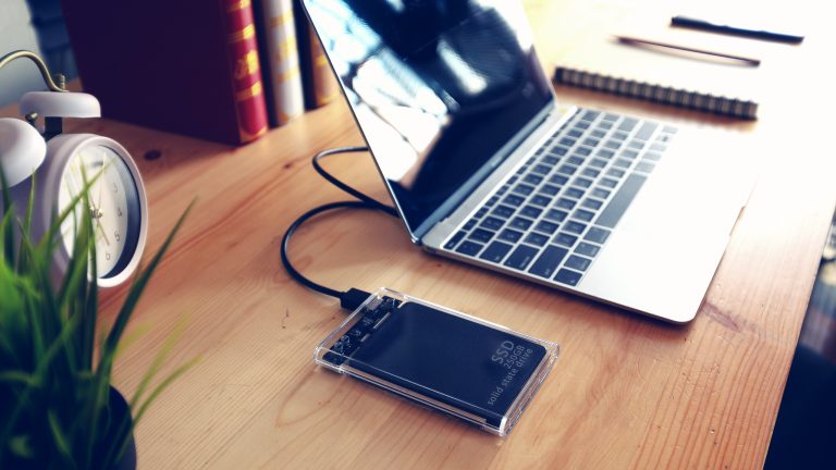 Eine externe SSD hängt an einem Laptop. Eine externe SSD hängt an einem Laptop.