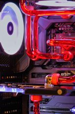 Blick in einen PC, in dem eine Wasserkühlung durch rote Schläuche fließt.