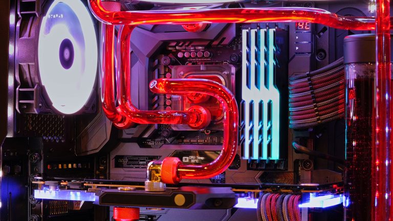 Blick in einen PC, in dem eine Wasserkühlung durch rote Schläuche fließt.