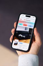 Eine Person hält ein iPhone in der Hand und macht einen Screenshot von UPDATED.
