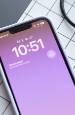 Ein iPhone 13 liegt auf einer Schneidematte. Auf dem Display werden der Sperrbildschirm und einige Symbole in der Statusleiste angezeigt.