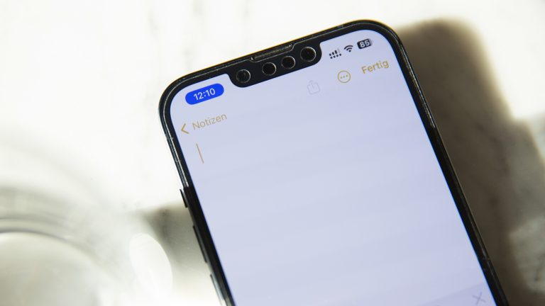 Nahaufnahme eines iPhone 13, auf dem die Notizen-App geöffnet ist. In der Statusleiste ist die Uhrzeit blau unterlegt, um anzuzeigen, dass die App die Ortungsdienste nutzt. Nahaufnahme eines iPhone 13, auf dem die Notizen-App geöffnet ist. In der Statusleiste ist die Uhrzeit blau unterlegt, um anzuzeigen, dass die App die Ortungsdienste nutzt.