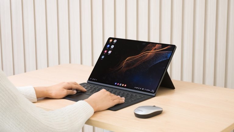 Ein Samsung Galaxy Tab S8 mit Book Cover auf einem Tisch. Eine Person tippt auf der Tastatur. Ein Samsung Galaxy Tab S8 mit Book Cover auf einem Tisch. Eine Person tippt auf der Tastatur.